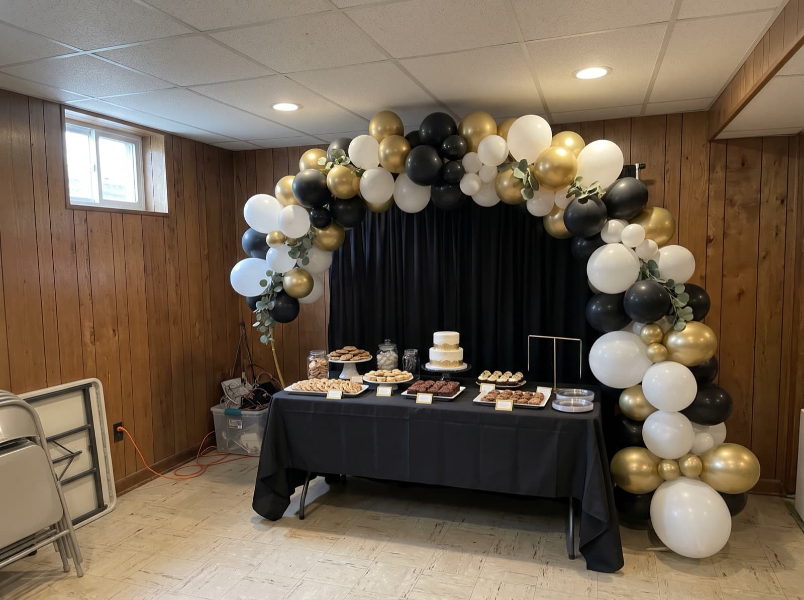 Organic balloon arch in black, white and gold over a dessert table at a Pittsburgh graduation party