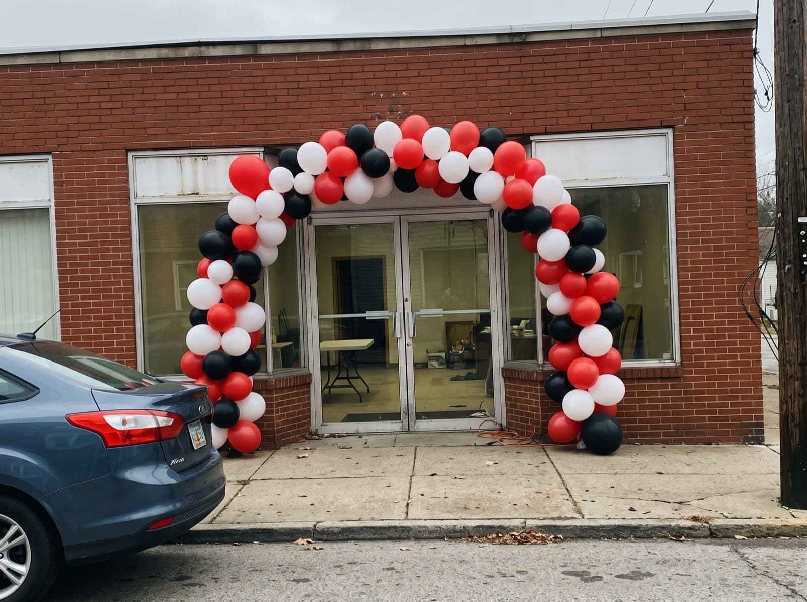 Large balloon arch over a small-business entrance