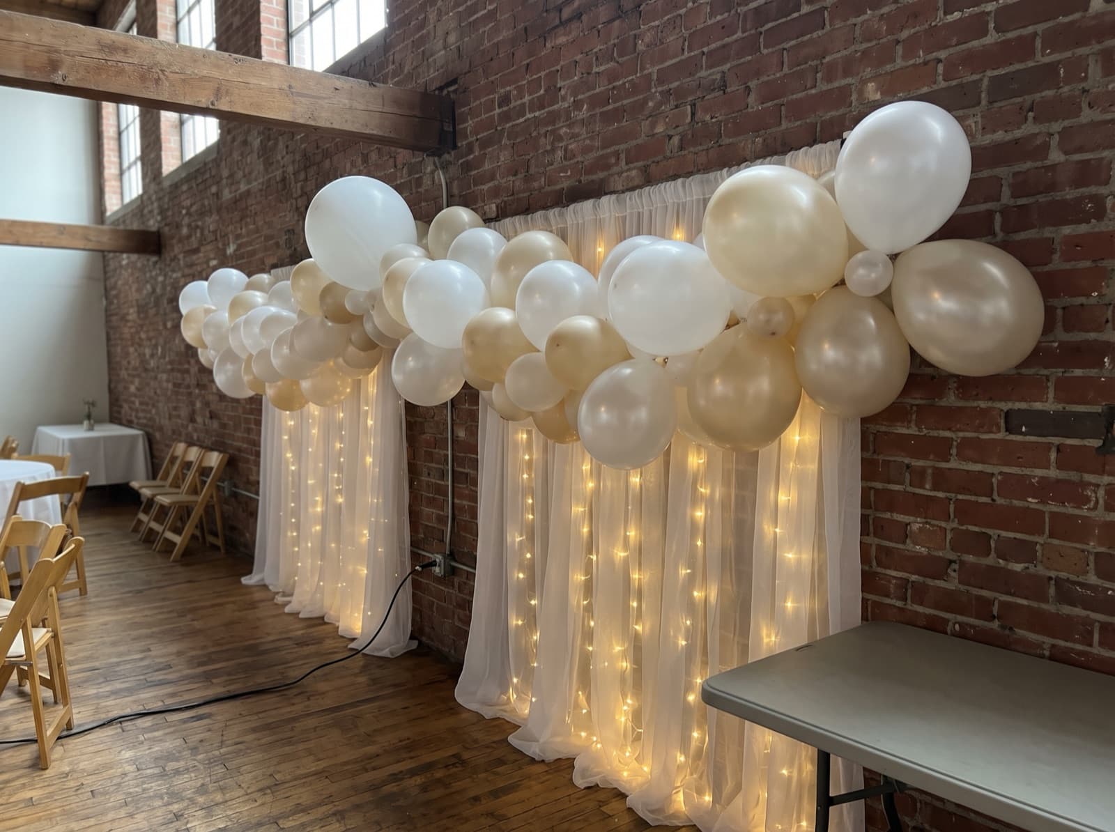 Draped backdrop with balloons and warm lights
