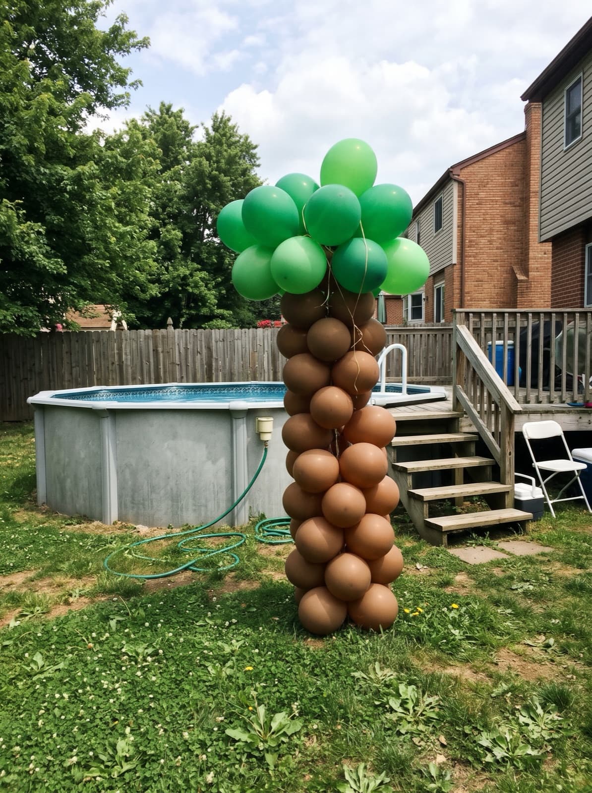 Palm tree balloon column beside an above-ground pool