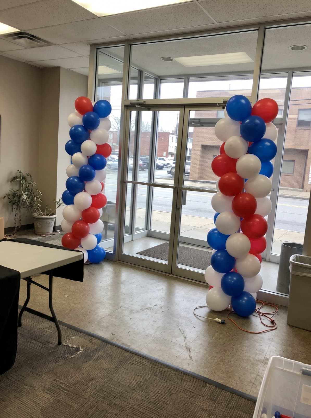 Red, white and blue spiral balloon columns at an office entrance