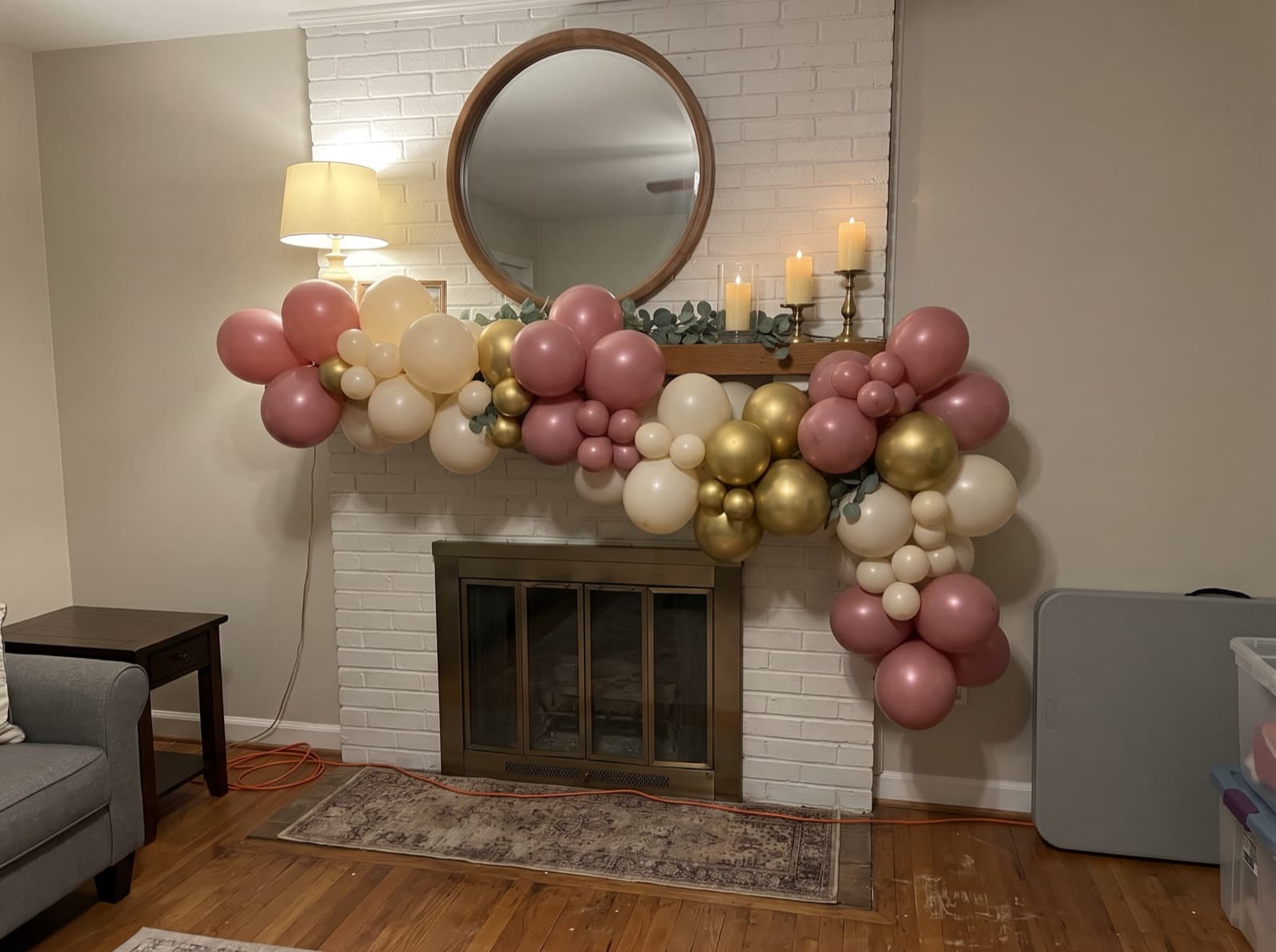 Organic balloon garland on a painted brick mantel