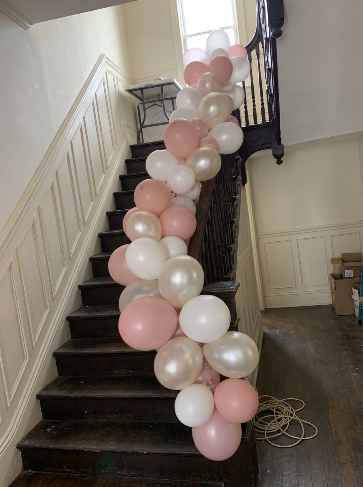 Balloon garland down an old wooden staircase banister