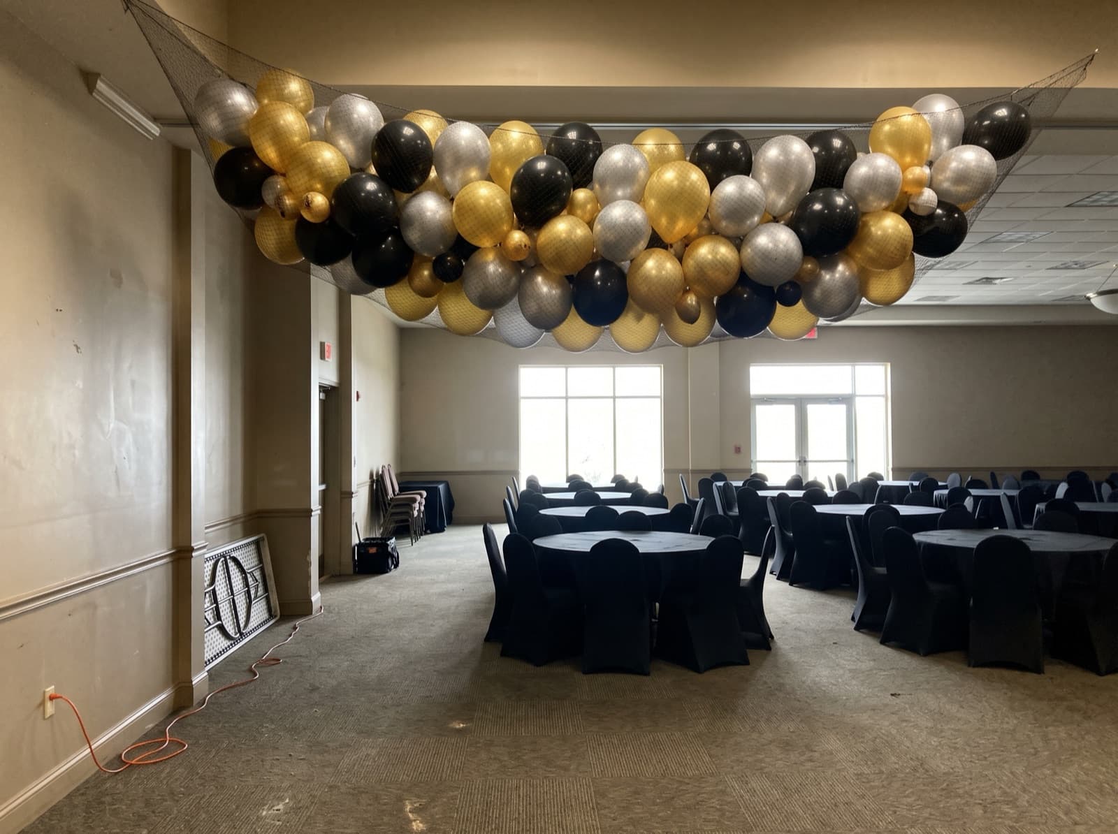 Balloon drop net above an empty ballroom