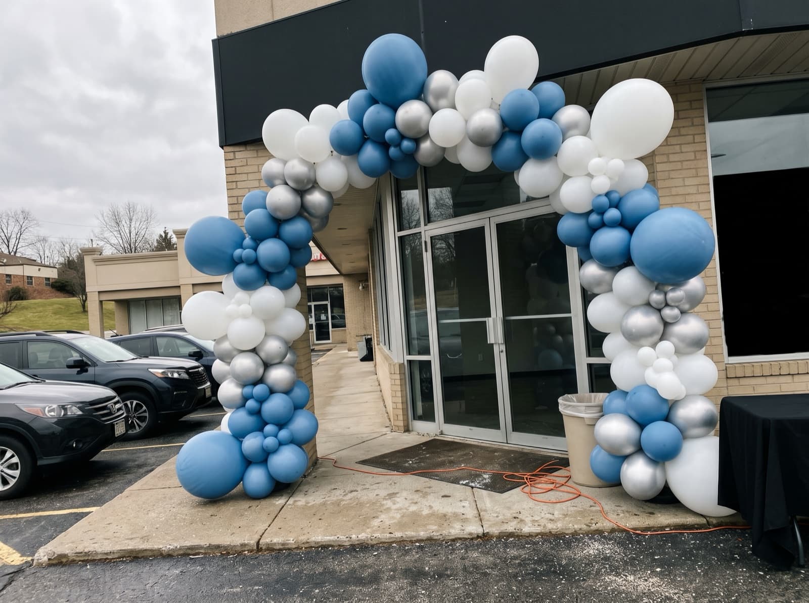 Giant balloon arch installation over a store entrance