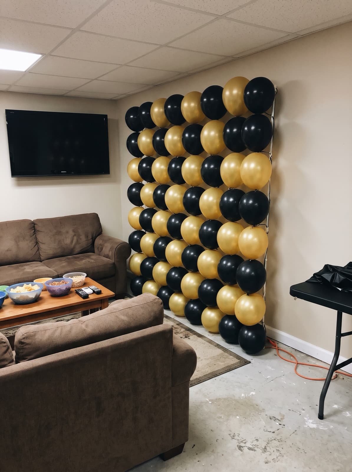 Grid balloon wall in a black and gold checkerboard